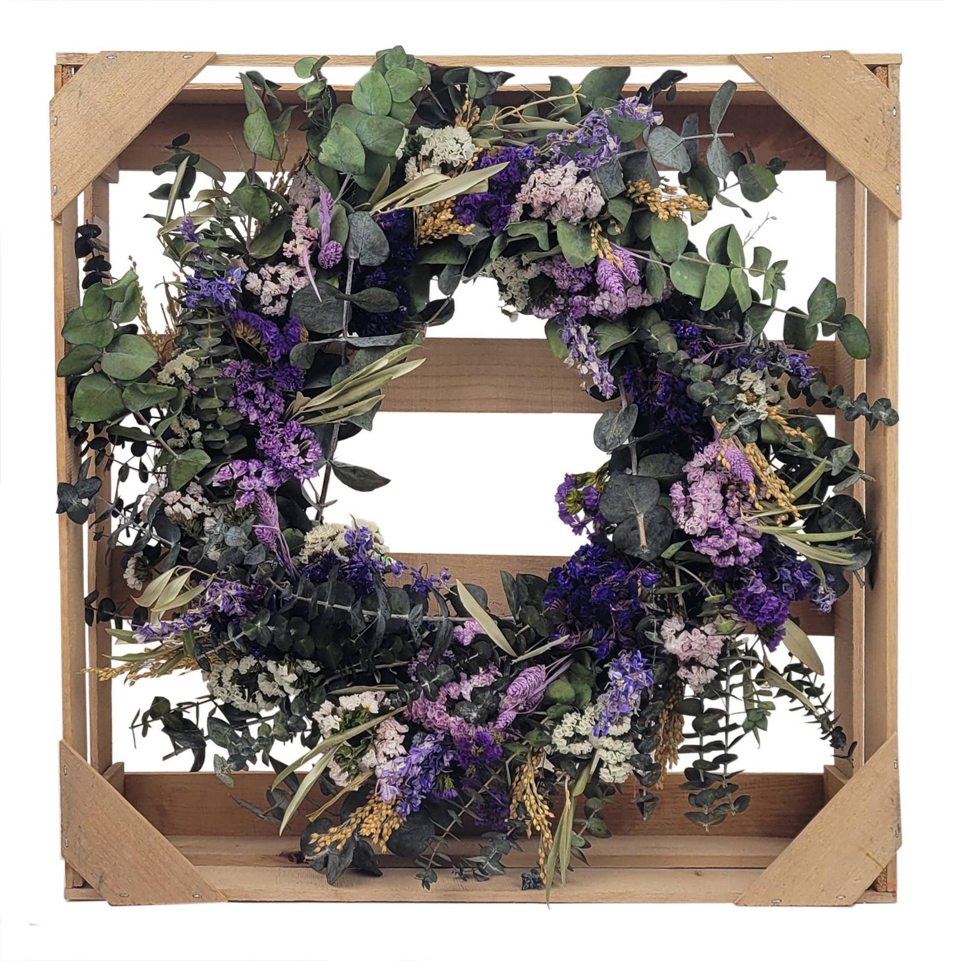 Lively Pasadena Wreath featuring baby eucalyptus and dried flowers, elegantly displayed in a wooden crate.