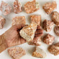 Hand holding a rough stone from the Chakra Rough Stone Crystal Set of 7 - Boxed Collection for energy balance.