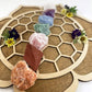 Chakra Rough Stone Crystal Set of 7 - Boxed Collection displayed on a wooden surface with flowers for energy balance.