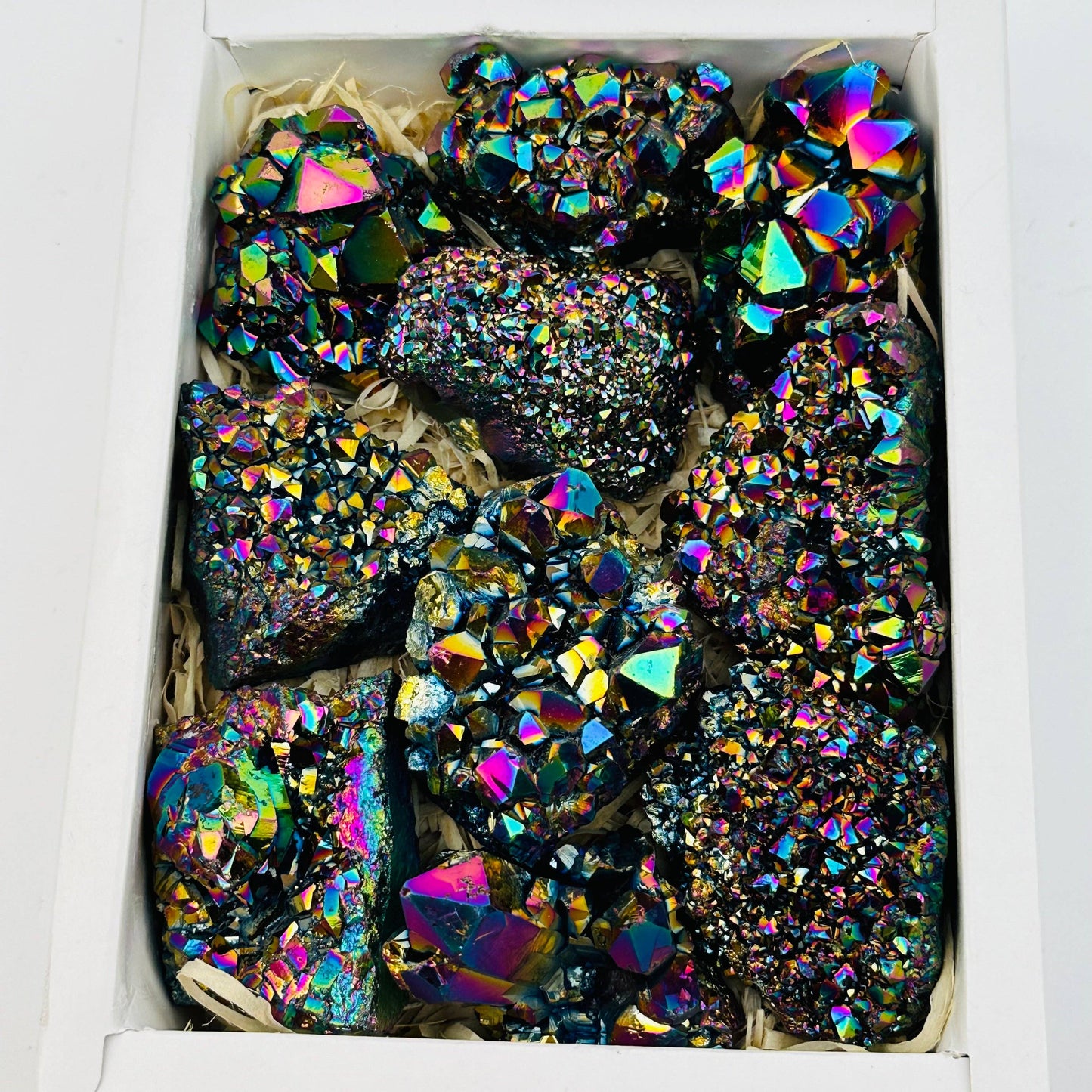 Colorful Amethyst Rainbow Titanium Crystals in a box, showcasing their stunning vibrancy and natural elegance.