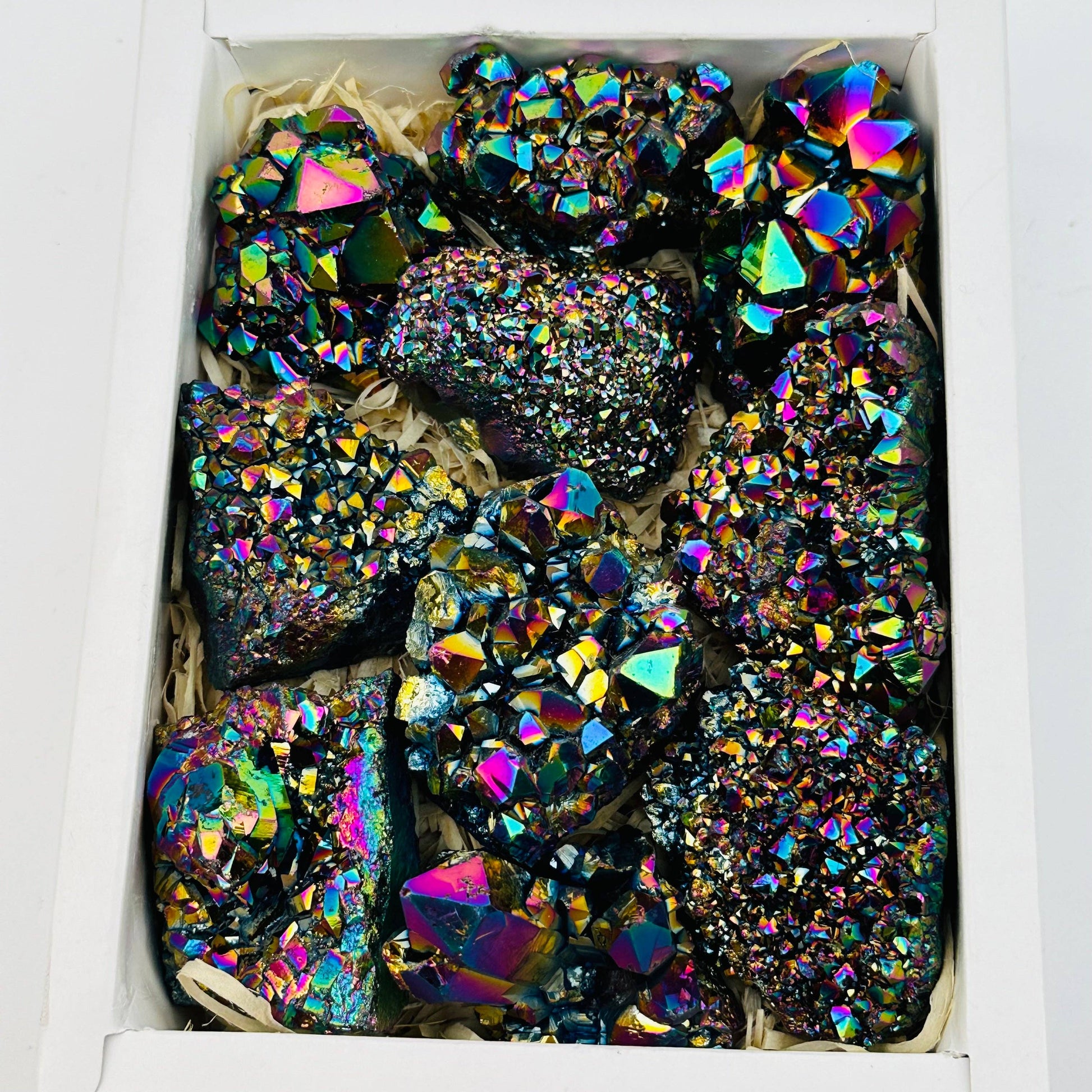 Colorful Amethyst Rainbow Titanium Crystals in a box, showcasing their stunning vibrancy and natural elegance.