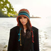 Woman wearing a colorful knitted hat by a body of water